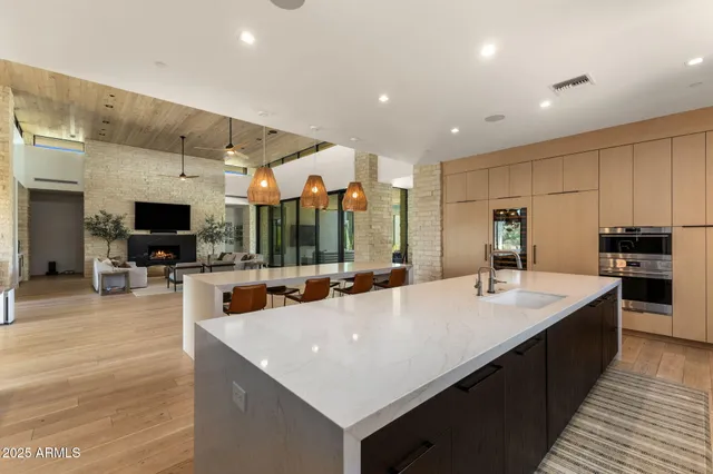a large kitchen with kitchen island a sink and a stove with wooden floor