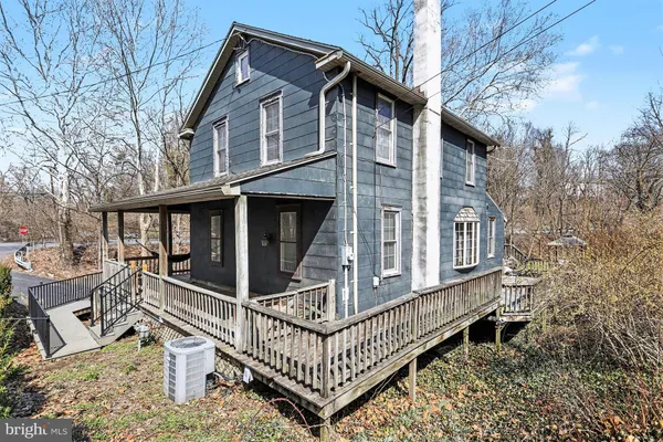 a view of a house with wooden fence and a large tree