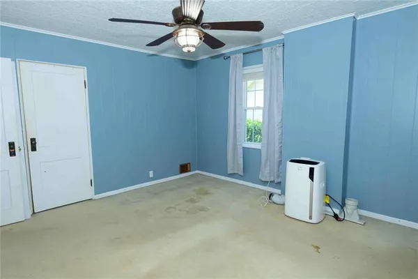 an empty room with windows and fan