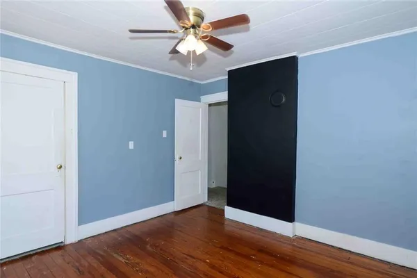 a view of an empty room with wooden floor