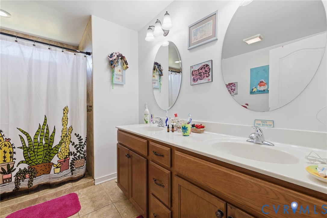 15900 Nobles Road Disputanta, VA 23842 - Photo 20 of 36 Bathroom with double vanity, a shower with curtain