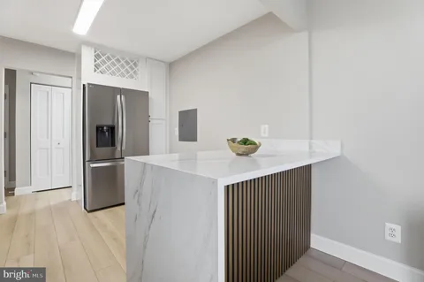 a kitchen with stainless steel appliances and wooden floor