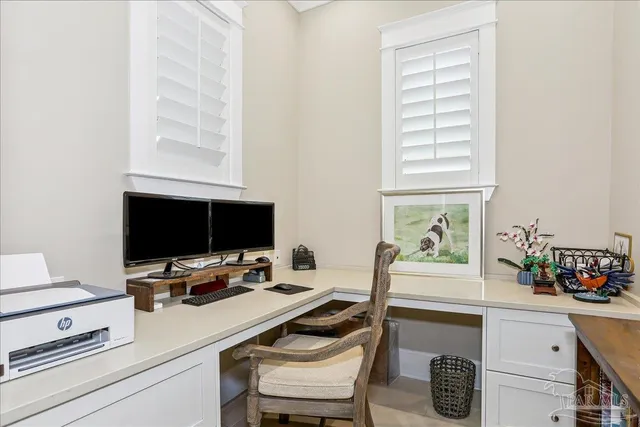 a view of a workspace with furniture and a window