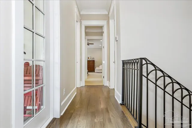 a view of a hallway with wooden floor and staircase