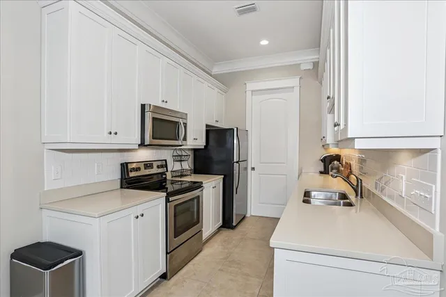 a kitchen with microwave a stove and cabinets