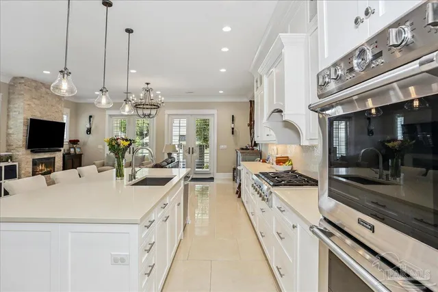 a kitchen with stainless steel appliances a stove top oven a sink a counter top space and cabinets