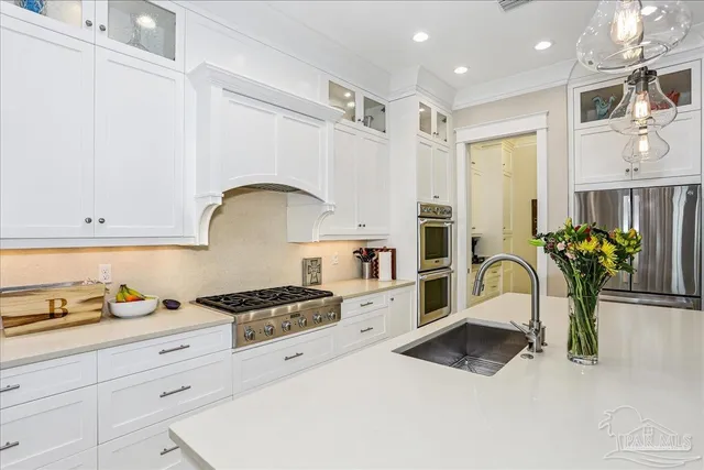 a kitchen with stainless steel appliances a white stove top oven and cabinets