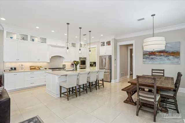 a kitchen with a dining table chairs and white cabinets