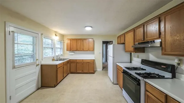 a kitchen with stainless steel appliances granite countertop a stove a sink and a refrigerator