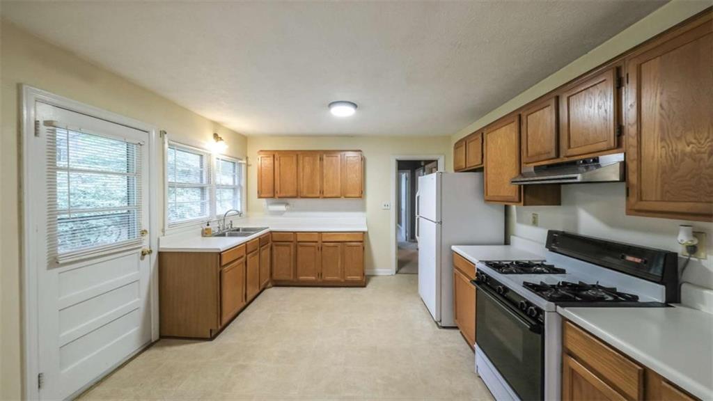 7146 Old Beulah Road Lithia Springs, GA 30122 - Photo 11 of 45 a kitchen with stainless steel appliances granite countertop a stove a sink and a refrigerator