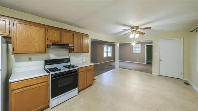 a kitchen with stainless steel appliances granite countertop a stove a sink and a refrigerator