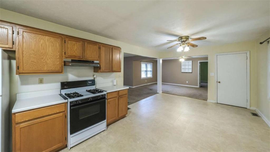 7146 Old Beulah Road Lithia Springs, GA 30122 - Photo 14 of 45 a kitchen with stainless steel appliances granite countertop a stove a sink and a refrigerator