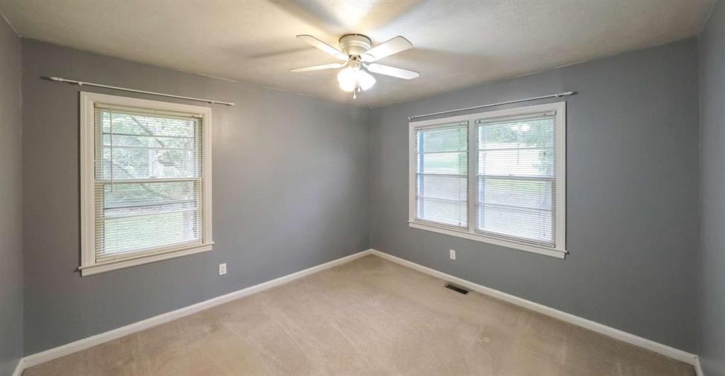 7146 Old Beulah Road Lithia Springs, GA 30122 - Photo 30 of 45 an empty room with windows and chandelier fan