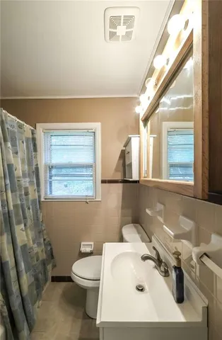 a bathroom with a sink a toilet and a mirror