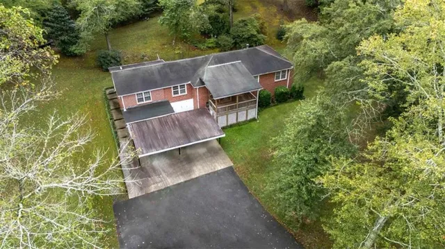 an aerial view of a house with a garden and lake view