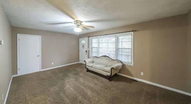 a living room with furniture and a ceiling fan