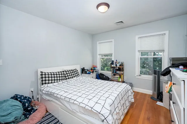 a bedroom with a bed and wooden floor