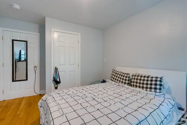 a bedroom with a bed and painting on the wall