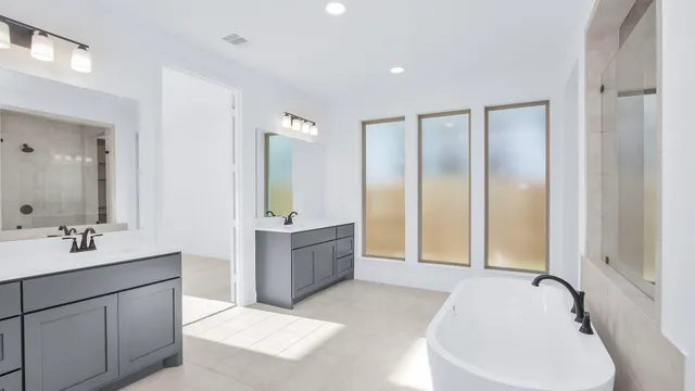 a spacious bathroom with a bathtub sink and mirror