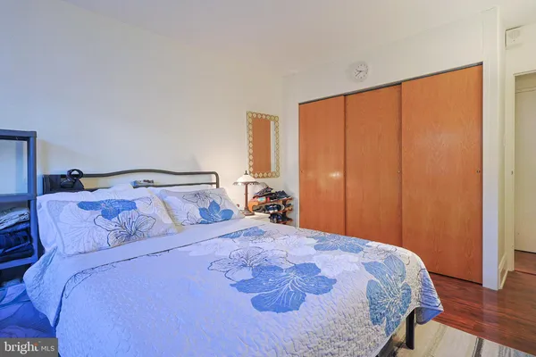 a bedroom with a large bed and wooden floor