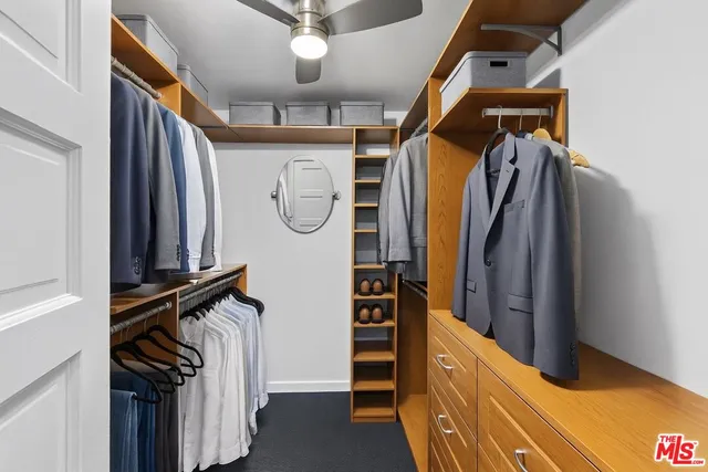 a view of walk in closet with clothes and shoes