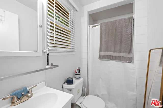 a bathroom with a sink a toilet and shower curtain