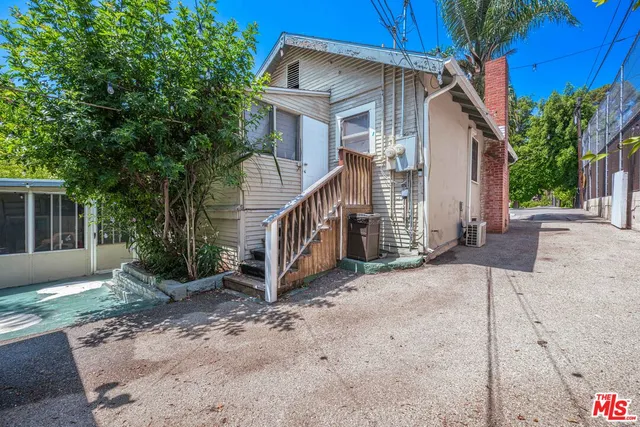a view of house with a yard and potted plants