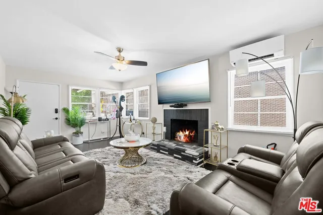 a living room with furniture a flat screen tv and a fireplace