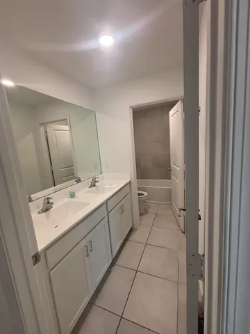 a bathroom with a sink a toilet and mirror