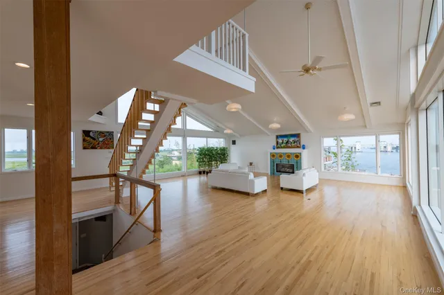 a view of a livingroom with furniture staircase window and wooden floor