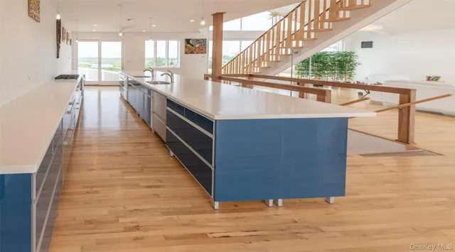 a view of kitchen with kitchen island wooden floor and living room