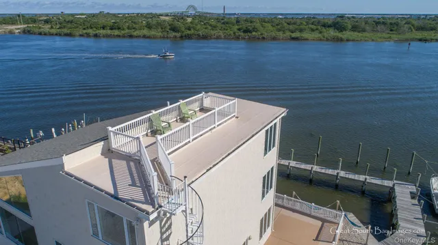 a view of a roof deck with lawn chairs wooden floor and lake view