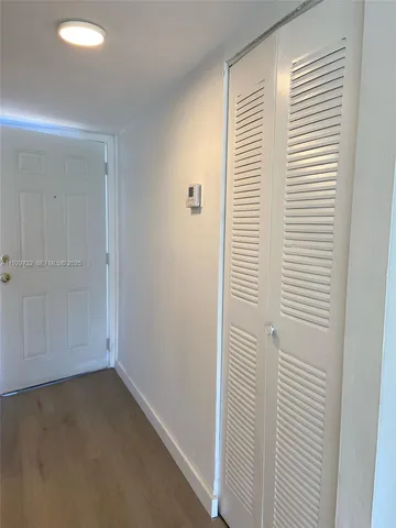 a view of a closet area with hardwood floor