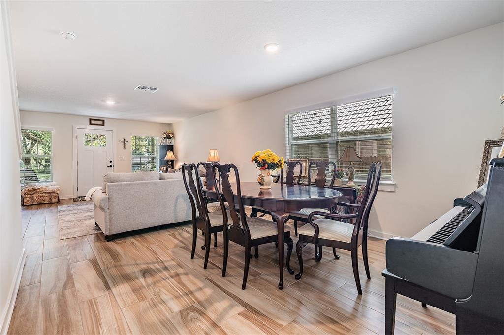17415 Sweetwater Road Dade City, FL 33523 - Photo 13 of 72 a view of a dining room with furniture and wooden floor