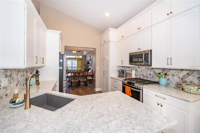 a kitchen with granite countertop a sink stove and cabinets