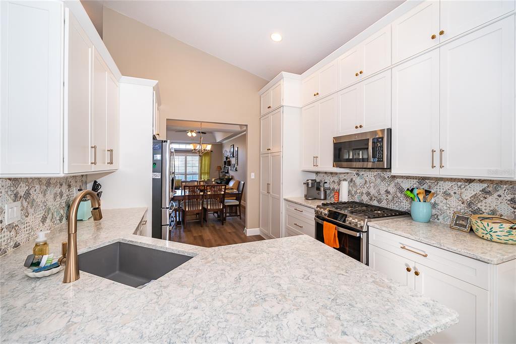 758 Seneca Meadows Road Winter Springs, FL 32708 - Photo 16 of 37 a kitchen with granite countertop a sink stove and cabinets