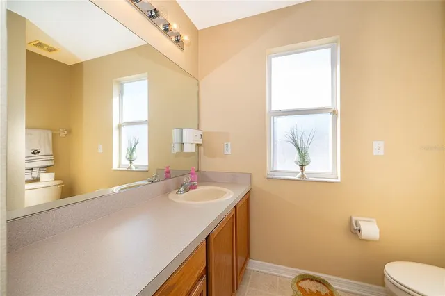 a bathroom with a sink a toilet and a window