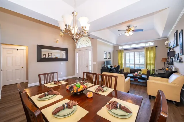 a living room with couches a dining table and chairs with wooden floor