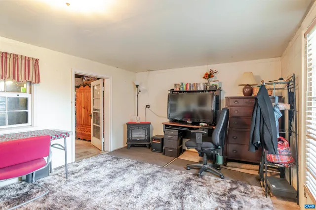 a view of a workspace with furniture and a window