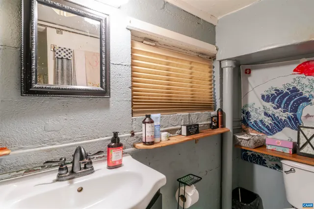 a bathroom with a sink a toilet and a mirror