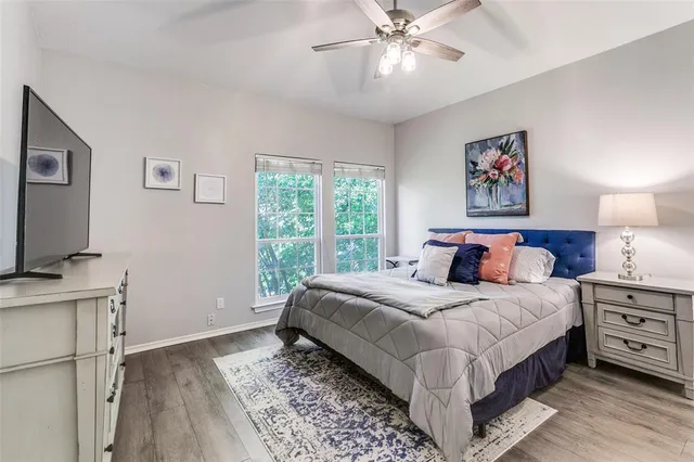 a bedroom with a large bed and a flat tv screen on dresser