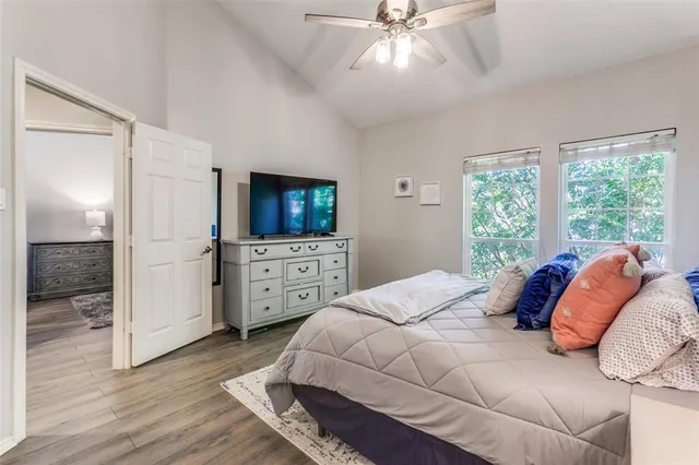 a bedroom with a large bed and a flat tv screen on dresser