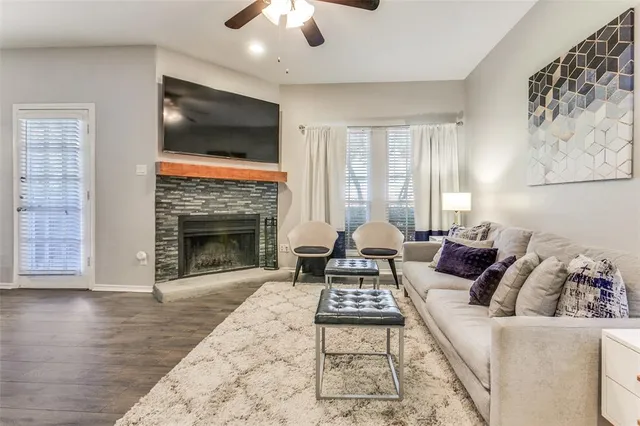 a living room with furniture a flat screen tv and a fireplace