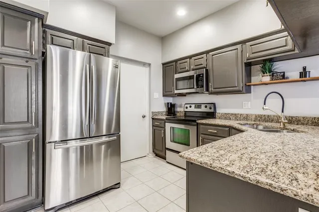 a kitchen with granite countertop a refrigerator and a sink