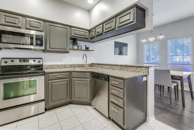 a kitchen with stainless steel appliances granite countertop a stove and a sink