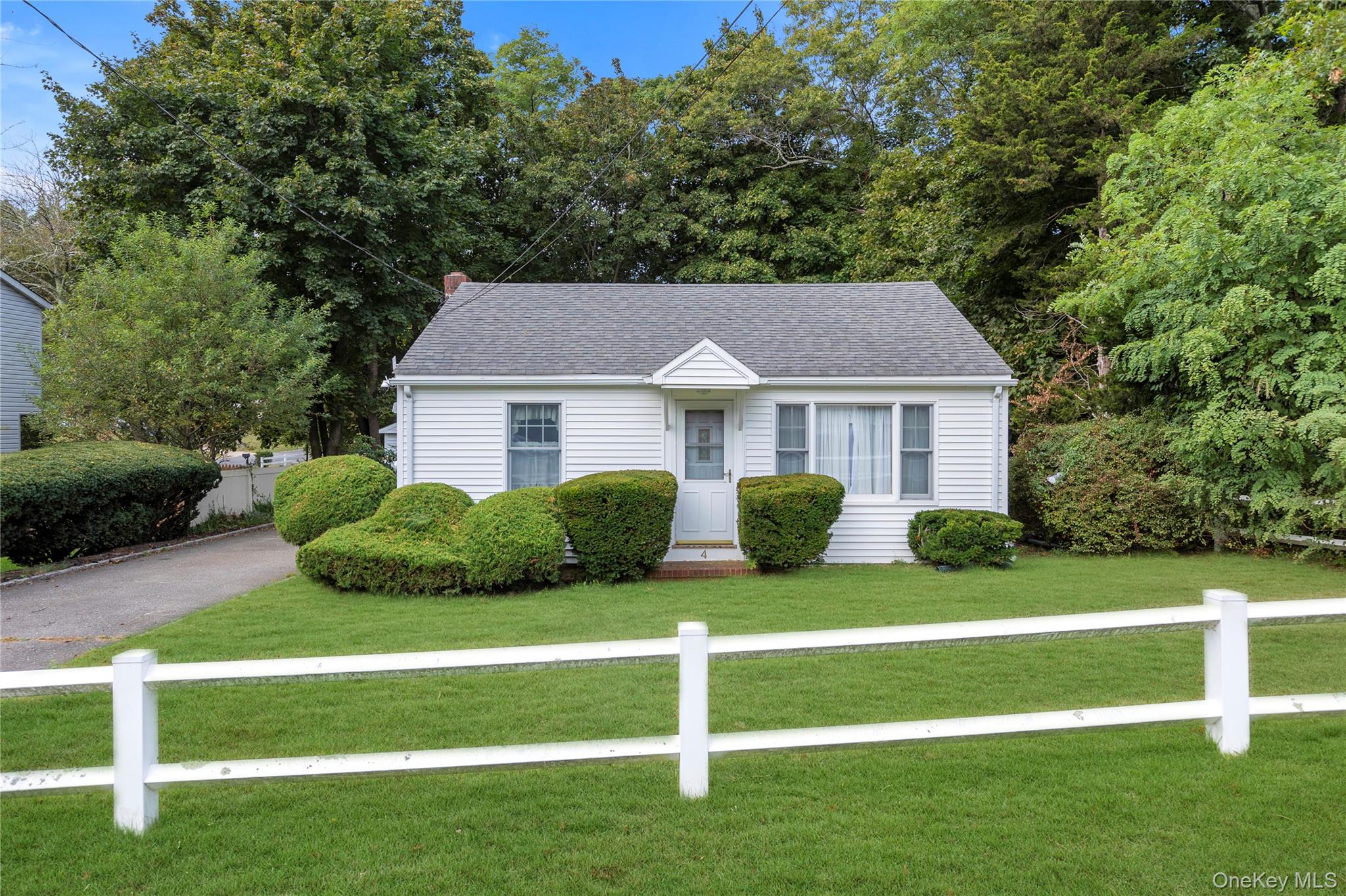 a front view of a house with a yard and trees