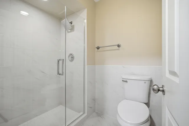 a white toilet next to a bathroom