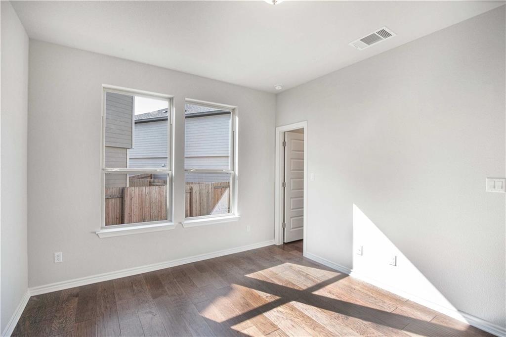 1616 Turtle Bay Loop Leander, TX 78641 - Photo 13 of 33 a view of an empty room with wooden floor and windows
