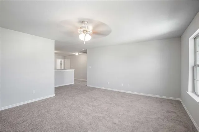 a view of an empty room and a ceiling fan