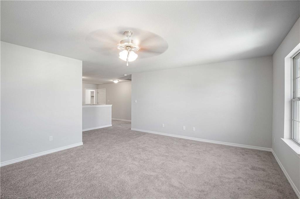 1616 Turtle Bay Loop Leander, TX 78641 - Photo 23 of 33 an empty room with a chandelier fan and windows